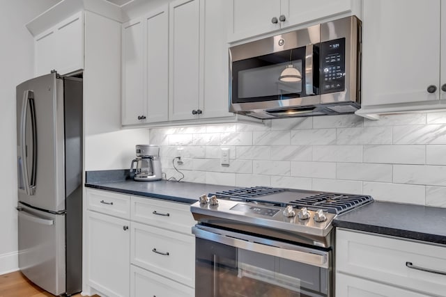 kitchen with decorative backsplash, stainless steel appliances, and white cabinets