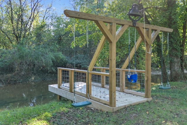 view of playground featuring a deck with water view