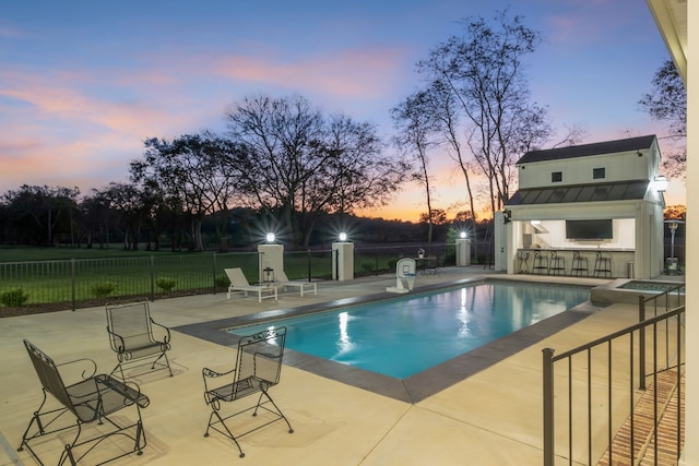 pool at dusk with a patio