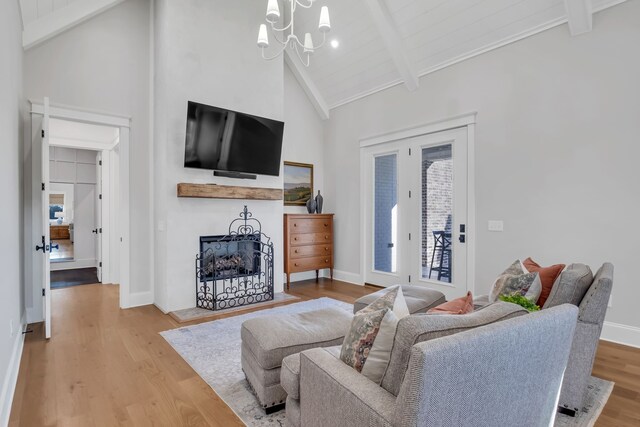 living room featuring wood-type flooring, beam ceiling, and high vaulted ceiling