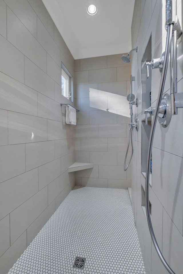 bathroom featuring tile walls and a tile shower