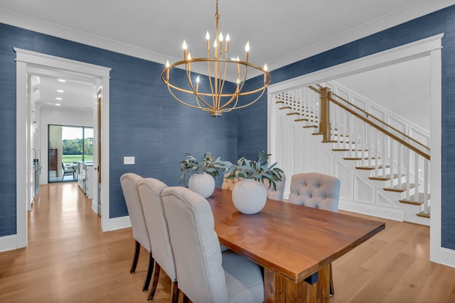 dining space with light hardwood / wood-style flooring, crown molding, and a chandelier