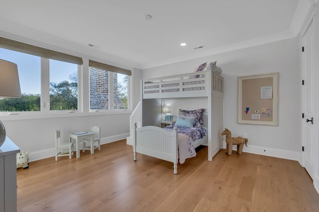 bedroom featuring ornamental molding and light hardwood / wood-style flooring