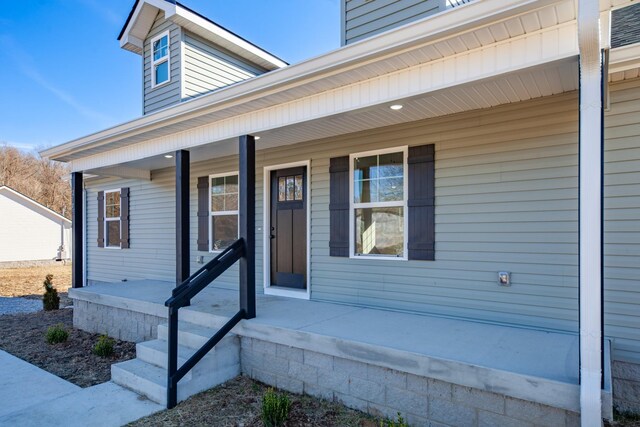 view of exterior entry featuring covered porch