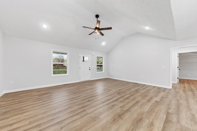 unfurnished living room featuring lofted ceiling, light wood finished floors, ceiling fan, and baseboards