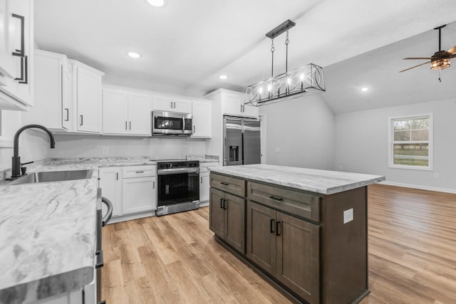 kitchen featuring white cabinets, light wood-style floors, stainless steel appliances, and a sink