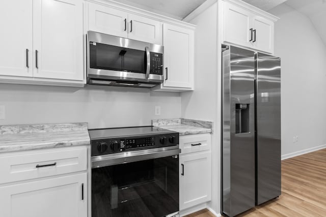 kitchen featuring baseboards, appliances with stainless steel finishes, light stone countertops, light wood-style floors, and white cabinetry