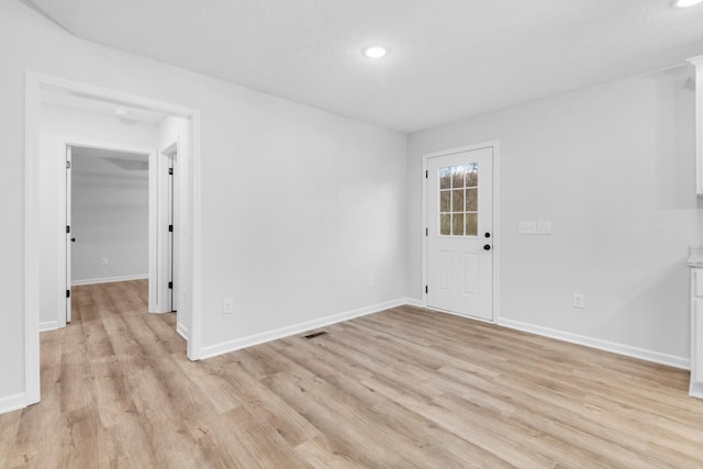 unfurnished room featuring light wood-style floors, recessed lighting, and baseboards