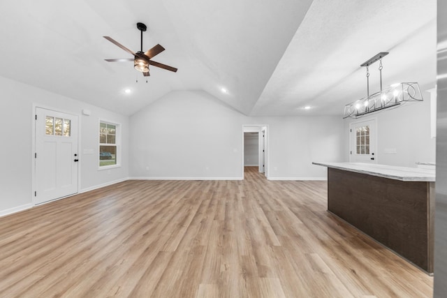 unfurnished living room featuring lofted ceiling, baseboards, a ceiling fan, and light wood-style floors