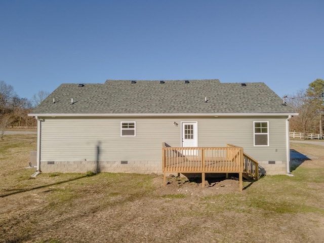 back of house featuring crawl space, a shingled roof, a deck, and a lawn