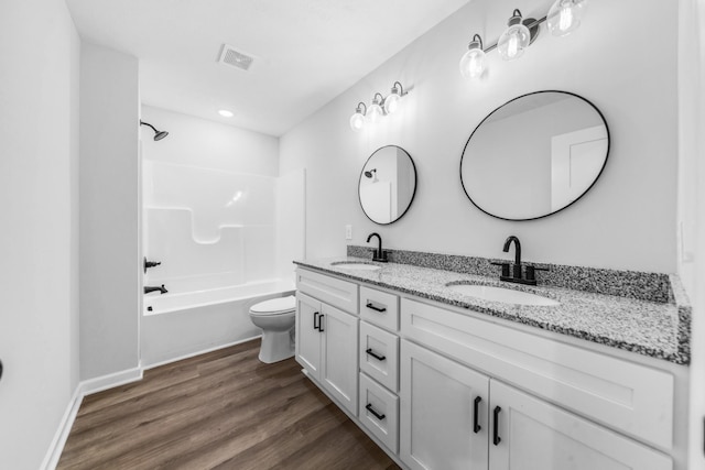 full bath featuring double vanity, wood finished floors, a sink, and visible vents