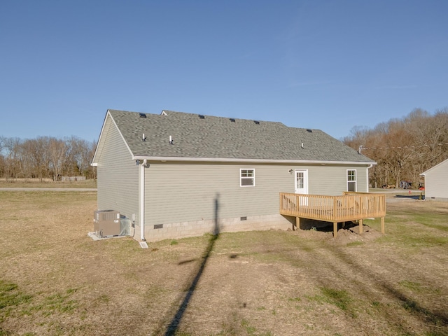 rear view of property with roof with shingles, central air condition unit, a lawn, crawl space, and a wooden deck