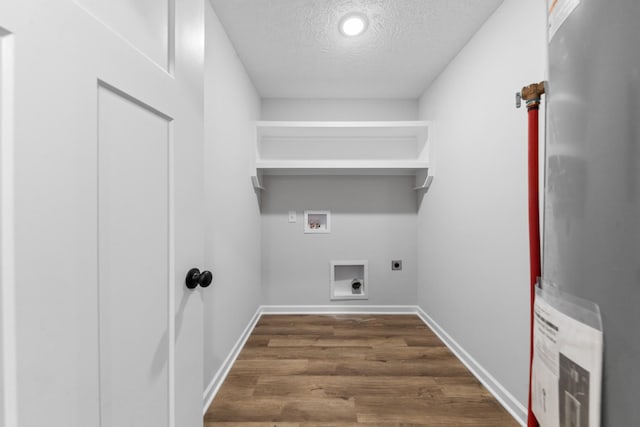 laundry area with laundry area, dark wood-style flooring, hookup for a washing machine, hookup for an electric dryer, and a textured ceiling