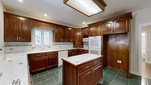 kitchen featuring dark tile patterned floors, sink, white appliances, and decorative backsplash