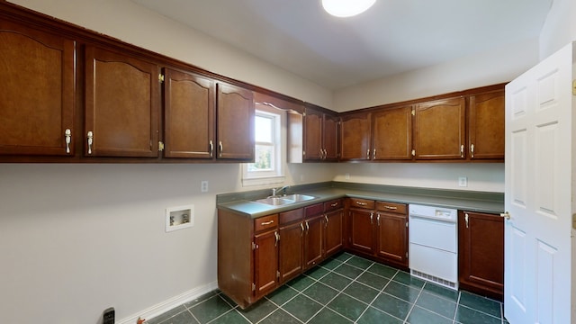 kitchen featuring dishwasher, sink, and dark tile patterned floors