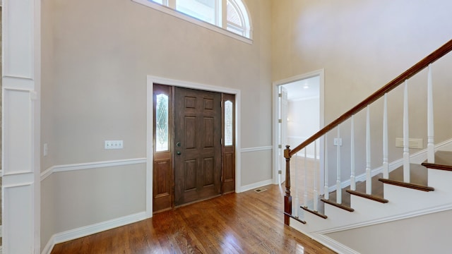 entrance foyer featuring a towering ceiling and dark hardwood / wood-style flooring