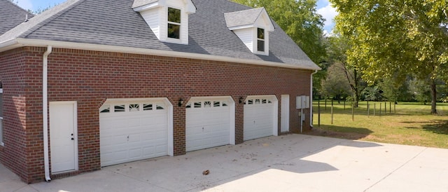 view of side of property with a yard and a garage