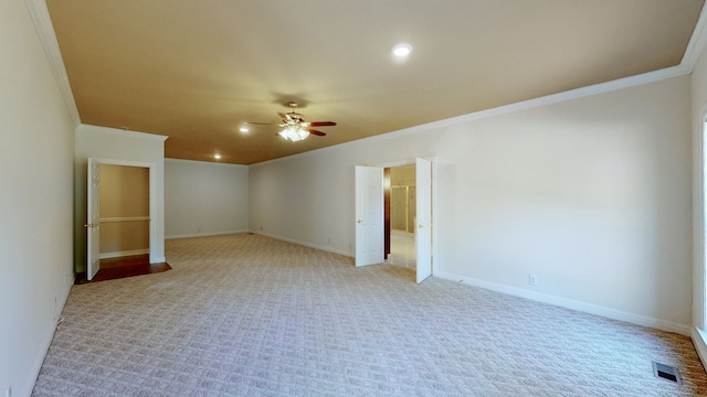 spare room featuring ornamental molding, light carpet, and ceiling fan