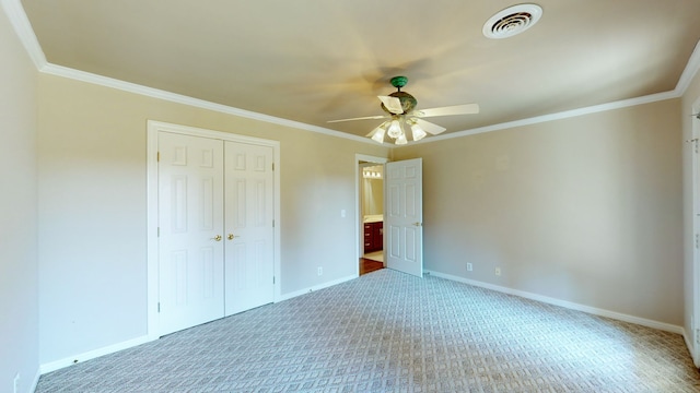 unfurnished bedroom featuring ornamental molding, a closet, ceiling fan, and carpet flooring