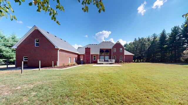 back of house featuring a lawn and central air condition unit