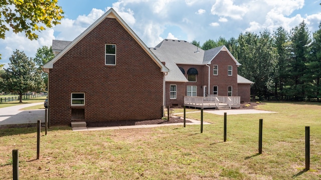 rear view of house with a deck and a yard