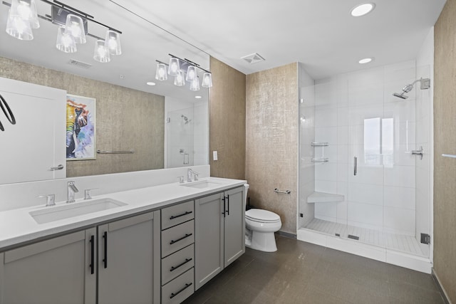 bathroom featuring toilet, tile patterned floors, vanity, and a shower with door