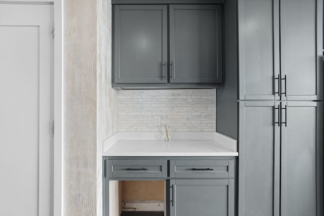 bar featuring gray cabinetry and decorative backsplash