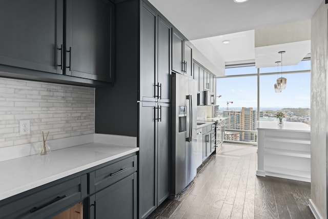 kitchen featuring stainless steel fridge with ice dispenser, dark hardwood / wood-style flooring, hanging light fixtures, and backsplash