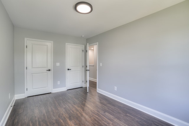 unfurnished bedroom with dark hardwood / wood-style floors