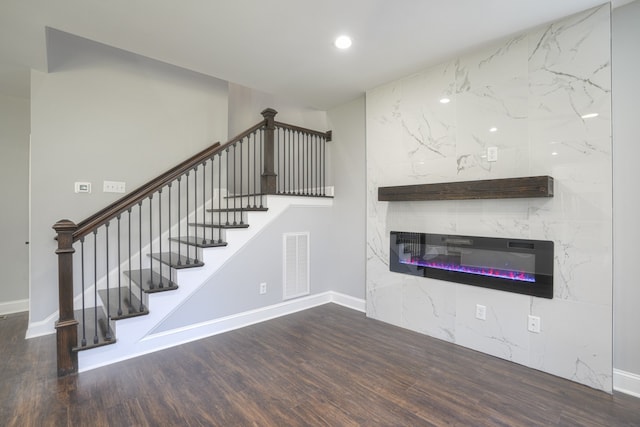 unfurnished living room with a premium fireplace and dark hardwood / wood-style flooring