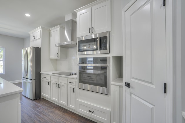 kitchen with white cabinets, stainless steel appliances, and wall chimney exhaust hood