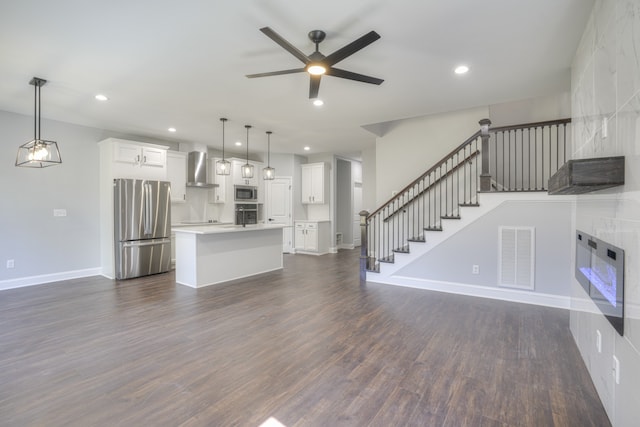 unfurnished living room featuring ceiling fan and dark hardwood / wood-style floors