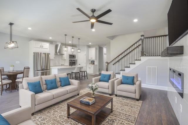 living room with light hardwood / wood-style flooring and ceiling fan