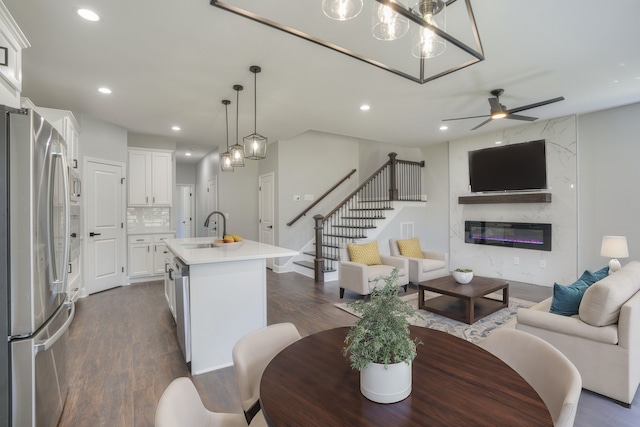 kitchen with white cabinets, sink, a kitchen island with sink, hardwood / wood-style flooring, and appliances with stainless steel finishes