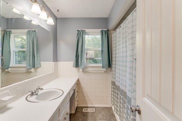 bathroom featuring tile walls, a wealth of natural light, tile patterned floors, and vanity