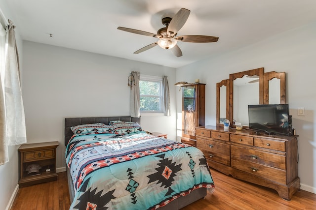 bedroom with ceiling fan and hardwood / wood-style flooring