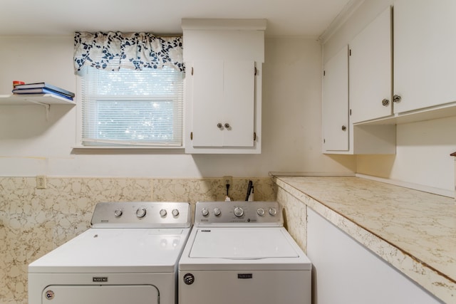 clothes washing area with cabinets and independent washer and dryer