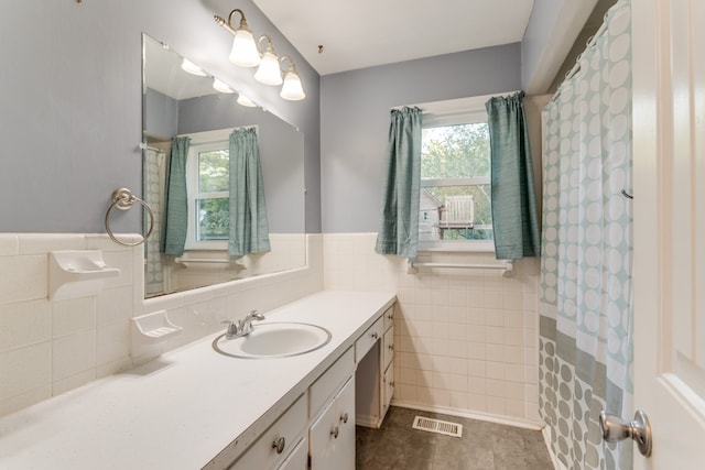 bathroom featuring tile walls, tile patterned flooring, and vanity