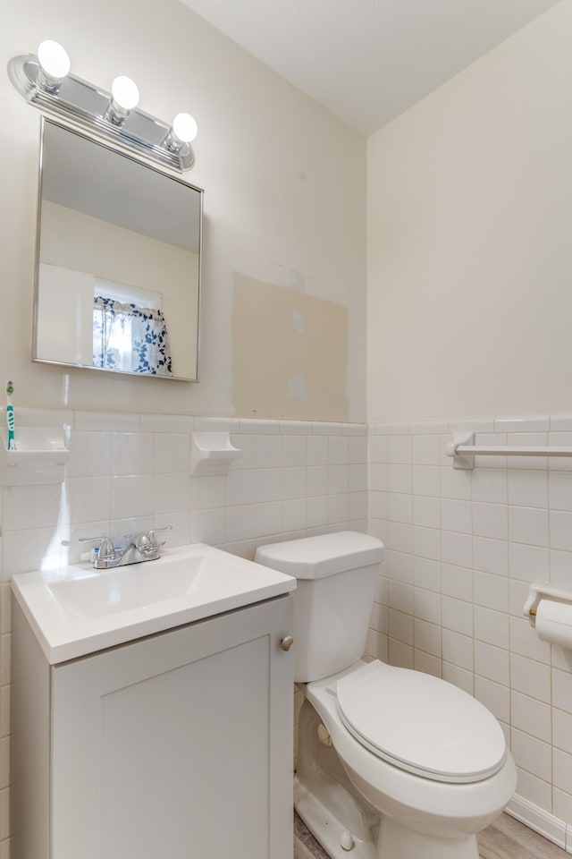 bathroom featuring tile walls, vanity, toilet, and hardwood / wood-style floors