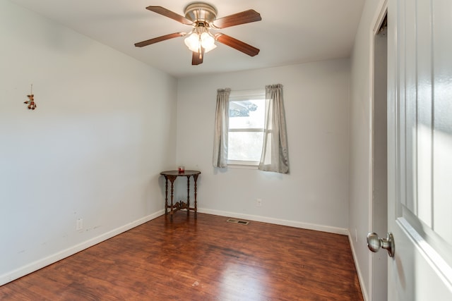 spare room featuring ceiling fan and dark wood-type flooring