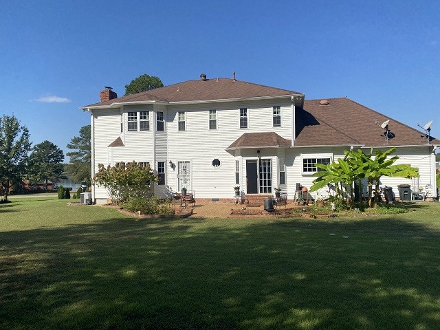 rear view of property featuring a lawn