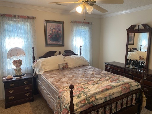 carpeted bedroom featuring ceiling fan, a textured ceiling, crown molding, and multiple windows