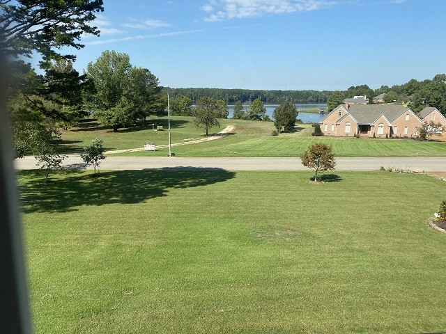 view of home's community with a yard and a water view