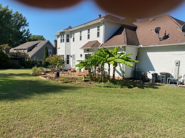 rear view of property featuring a lawn