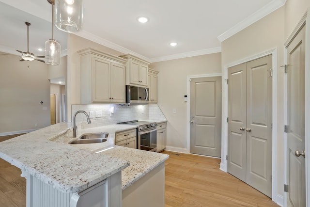 kitchen with sink, light hardwood / wood-style flooring, stainless steel appliances, and decorative light fixtures