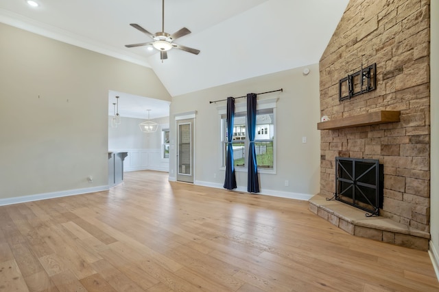 unfurnished living room featuring ceiling fan, light wood-type flooring, a fireplace, and ornamental molding