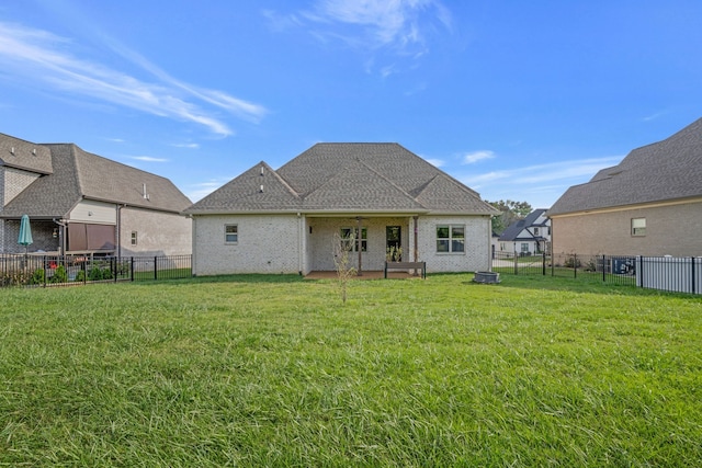 back of property with a lawn and a patio