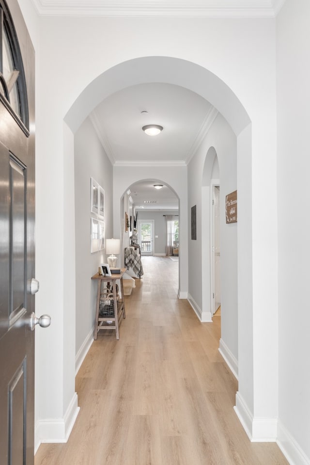 hall with light hardwood / wood-style flooring and ornamental molding