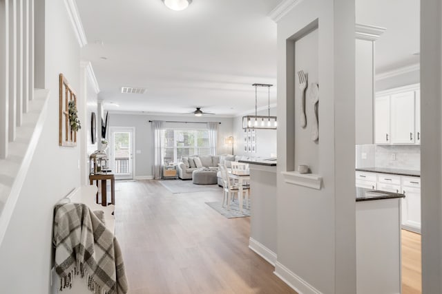 corridor featuring ornamental molding and light hardwood / wood-style floors