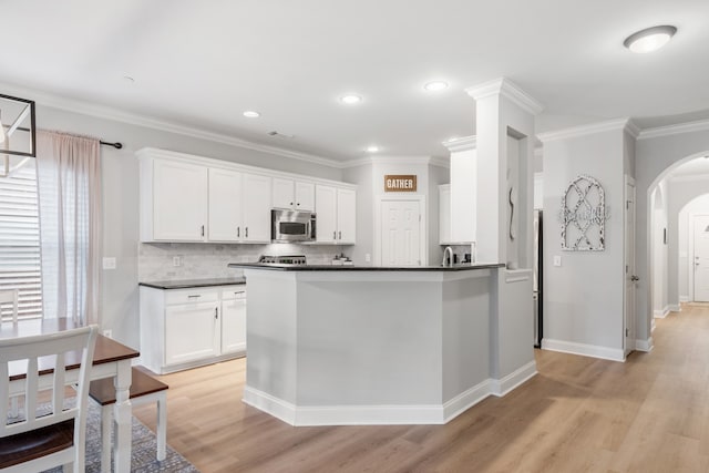 kitchen featuring white cabinetry, light hardwood / wood-style floors, and crown molding